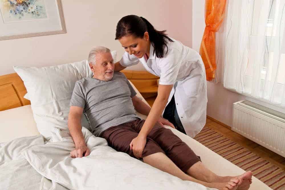 Aide-soignante accompagnant une personne âgée dans une maison de retraite