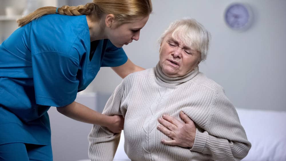 Accompagnante auprès d'une résidente âgée qui ressent une douleur à la poitrine en maison de retraite